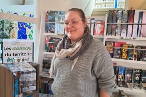 Sophie Saint, responsable de la bibliothèque, près de l'étagère dédiée aux auteurs locaux.